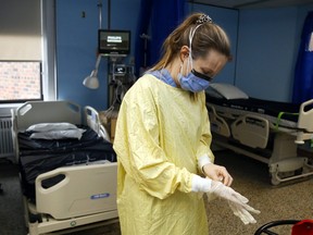 Registered nurse Courtney Benoit dons gloves and other personal protective equipment before tending to a patient in the special-care unit of Campbellford Memorial Hospital. The hospital needs multiple major repairs and upgrades; a new facility is also proposed.