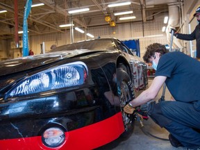 Ron Sheridan with The Pit Crew Challenge keeps an eye on Grade 12 student Ty Legroulx as he changes a tire on a race car during a skilled trades boot camp at St. Michael Catholic secondary school in Stratford on Tuesday. Chris MontaniniStratford Beacon Herald