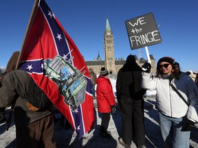 A supporter carries a US Confederate flag during the Freedom Convoy protesting  Covid-19 vaccine mandates and restrictions in front of Parliament on January 29, 2022 in Ottawa, Canada. Photo by DAVE CHAN/AFP via Getty Images