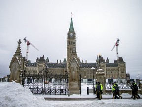 Police walk outside Parliament Hill in Ottawa on Sunday, February 20, 2022 after officers pushed “Freedom Convoy” protesters out of the area.