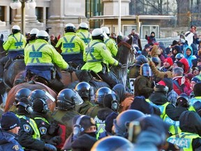 A mounted police horse unit pushes back a crowd during a protest against COVID-19 mandates in Ottawa on Feb. 18.