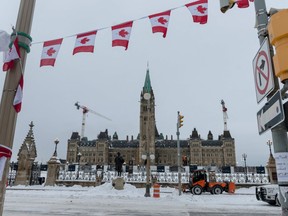 Ottawa City employees clean up Wellington Street Saturday in front of Parliament Hill, previously occupied by the so-called Freedom Convoy. ANDREJ IVANOV/AFP via Getty Images