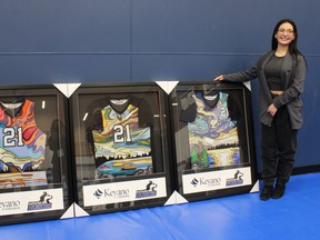 ACFN artist Emma Voyageur poses next to the Keyano Huskies jerseys she designed after a ceremony at the college's Syncrude Sport and Wellness Centre on Friday, February 18, 2022. Vincent McDermott/Fort McMurray Today/Postmedia Network