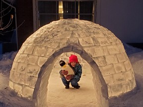 Eight-year-old Charlotte Bellemare sits inside the igloo her family created in their front yard on Pinegrove Crescent. The family made 250 blocks of ice to create the igloo. Submitted Photo