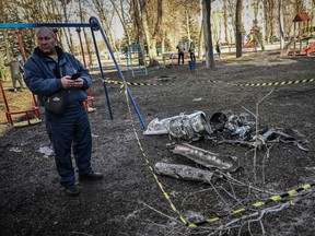 A man stands next to remains of a missile in the eastern Ukraine city of Kharkiv on February 24, 2022, as Russian armed forces launched a military invasion of Ukraine. - The Russian president launched a full-scale invasion of Ukraine on Thursday, killing dozens and forcing hundreds to flee for their lives in the pro-Western neighbour. Russian air strikes hit military facilities across the country and ground forces moved in from the north, south and east, triggering condemnation from Western leaders and warnings of massive sanctions. (Photo by Aris Messinis / AFP) (Photo by ARIS MESSINIS/AFP via Getty Images)