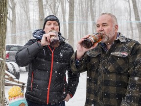 Bay of Quinte MP Ryan Williams, left, and MPP Todd Smith both enjoy a sip of maple syrup from Fosterholm Farms after tapping two trees. The tree tapping marks the start of the maple syrup harvest in Ontario. Saturday in Prince Edward County. ALEX FILIPE