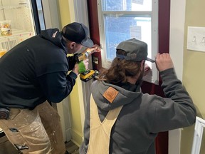 Workers from Collective Construction repair a door at Mitchell's Cafe after the business was broken into on Jan. 31, 2022. Supplied Image/Mitchell's Cafe