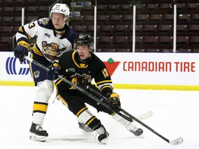 Sarnia Sting's Josh Vogelsberg, right, battles Erie Otters' Cameron Morton in the first period at Progressive Auto Sales Arena in Sarnia, Ont., on Friday, Feb. 4, 2022. Mark Malone/Chatham Daily News/Sarnia Observer