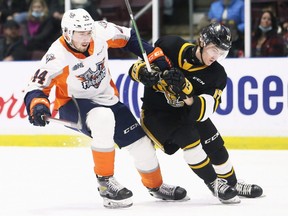 Sarnia Sting's Alexis Daviault, right, fights off a check by Flint Firebirds' Zack Terry in the first period at Progressive Auto Sales Arena in Sarnia, Ont., on Monday, Feb. 21, 2022. Mark Malone/Chatham Daily News/Postmedia Network