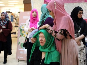 Sundas Shamshad wraps a hijab around former councillor Verna Murphy at Peter Pond mall to celebrate World Hijab Day on Saturday, February 1, 2020. Laura Beamish/Fort McMurray Today/Postmedia Network