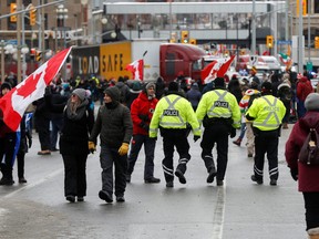 Police officers walk in the crowd as truckers and supporters continue to protest vaccine mandates in Ottawa on Sunday.