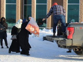 Volunteers deliver winter and hygiene kits to a community member outside the Fort McMurray Islamic Centre on Feb. 5, 2022. Jenna Hamilton/Fort McMurray Today/Postmedia Network