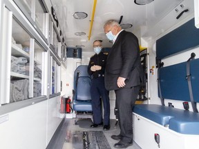 Ontario Premier Doug Ford is shown a new Middlesex-London Paramedic ambulance by Neal Roberts, chief of Middlesex-London Emergency Medical Services Authority, during a brief stop at their headquarters on Adelaide Street South in London. Photo taken on Friday Feb. 25, 2022. (Mike Hensen/The London Free Press)