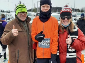 Dylan Campbell (centre) poses with Rick Mannen of the Running with Rick club and Mannen's wife, Josie. Submitted