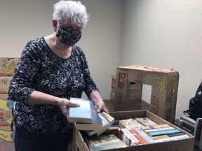 Penny MacKenzie, a volunteer with the Brantford Symphony Orchestra book fair committee, sorts donated books. The committee has cancelled its in-person sale for the third time in as many years and instead will hold another online auction in April. Submitted