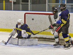 Christian Ligori (second from right) of the St. John's Eagles watches as a shot by team-mate Sebastian DeGrandis soars over the shoulder of McKinnon Park goalie Rhys Wide during a high school boys hockey game on Tuesday February 22, 2022 at the Wayne Gretzky Sports Centre in Brantford, Ontario. Brian Thompson/Brantford Expositor/Postmedia Network