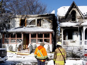 Township of Leeds and the Thousand Islands (TLTI) fire chief Mike Prior, right, stands in front of the scene of two houses that have been damaged by a fire. Both Gananoque and TLTI fire departments battled the blaze on Thursday night.