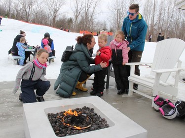 Spending some time at the fire pit area at Big Ben Ski Centre on Monday afternoon are the Demerchant kids, from left, Lyla, Miller and Evie, with mom and dad Jessica and Colby. Photo on Monday, February 21, 2022, in Cornwall, Ontario.Todd Hambleton/Standard-Freeholder/Postmedia Network