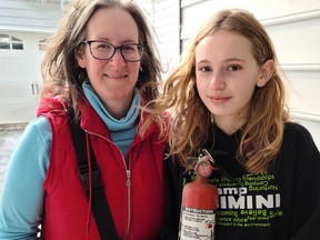 Brooke Workman (right) holds the fire extinguisher she used to put out a small fire that started with the microwave in the family's Adelaine Street kitchen in Mitchell Feb. 16. Proud mom Lise-Anne and WPFD Fire Prevention Officer James Marshall said her actions are reminders to keep fire extinguishers handy and know how to use them.