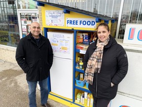 Saeed and Merola Tahmattan with the Parry & Peonies community fridge outside their store, Family News Stand, at 506 Days Rd.  In Kingston, on Thursday.