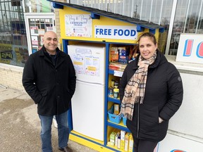 Saeed and Merola Tahmattan with the Parry & Peonies community fridge outside their store, Family News Stand, at 506 Days Rd. In Kingston, on Thursday.