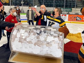 Bill Welychka holds the winning Kinsmen Dream Home lottery ticket for chair Graham Forsythe after it was drawn at the Leon’s Centre in Kingston on Friday during a Kingston Frontenacs game.