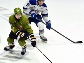 Kyle Jackson of the North Bay Battalion competes for the puck with Alex Assadourian of the visiting Sudbury Wolves on Sunday. It was Jackson's 100th Ontario Hockey League game.