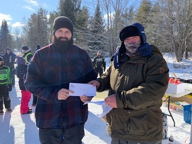 Noah Brandt (left) accepts his second-place prize from Rick Klatt, volunteer co-ordination of the Laurentian Valley Ice Fishing Derby, following the event held on Lemke Lake Feb. 12.
