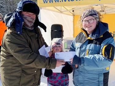 Maddie Coulas caught the fourth largest fish during the third annual Laurentian Valley Ice Fishing Derby, held Feb. 12 on Lemke Lake. She accepted her prize from Rick Klatt (right), volunteer co-ordination of the derby, while her sister Molly looked on.