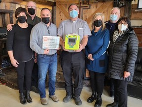 The Grind Pembroke now has an automated external defibrillator thanks to a donation from the Chase McEachern AED Memorial Fund in memory of former Pembroke resident Ted O'Brien. Taking part in the official unveiling Feb. 4 (from left) were Ted's in-laws Alison and Jeff Bahm, The Grind executive director Jerry Novack, The Grind Community Kitchen chairman Deacon Adrien Chaput, Ted's widow Laurie O'Brien and John and Dorothy McEachern, Chase's parents who are keeping his dream alive.