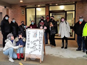 A small crowd gathered at Melbourne's Townline Terrace to take in Groundhog Day festivities on Feb. 2. Youngster Byron Vanderwerf is standing in front of the sign, eating a groundhog-shaped cookie with his mother Nicole and father Blake look on. Handout/Strathroy Age Dispatch