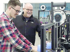 Joe Bertrand (right) and Riley Drover calibrate a machine at Maker North in this photo taken before the pandemic.