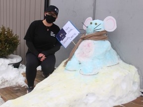 Store manager Colleen Keating is shown next to the snow sculpture outside of The Cheese Wedge in Point Edward.