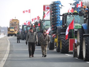 Protesters walk along a closed section of westbound Highway 402 Wednesday morning in Lambton County.