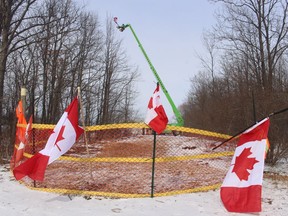 A temporary fence and flags mark a path Sunday leading to spot where supporters were gathered next to a “Freedom Convoy” demonstration that has led to the shutdown of a section of the westbound lanes of Highway 402.
