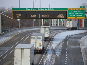 Trucks travel west Sunday morning on the Highway 402 approach to the Blue Water Bridge in Point Edward.