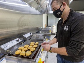 Kelvin Van Rijn, the owner of the Fritter Shop, is shown in this file photo taking out a rack of deep fried fritters at The Grove at Western Fair District in London.