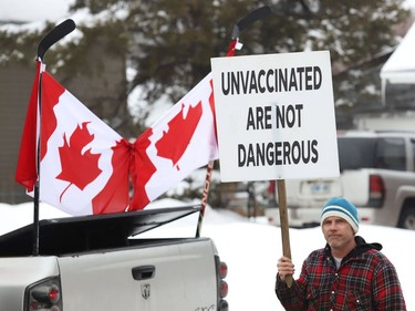 A demonstrator takes part in a protest of COVID-19 mandates near the entrance to Lo-Ellen Park Secondary School in Sudbury, Ont. on Friday February 11, 2022. John Lappa/Sudbury Star/Postmedia Network
