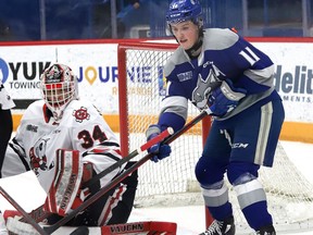 Landon McCallum, right, of the Sudbury Wolves, attempts to deflect a shot in front of goalie Josh Rosenzweig, of the Niagara IceDogs, during OHL action at the Sudbury Community Arena in Sudbury, Ont. on Friday February 11, 2022. John Lappa/Sudbury Star/Postmedia Network