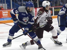 Nick DeGrazia, left, of the Sudbury Wolves, and James Guo, of the Peterborough Petes, battle for position during OHL action at the Sudbury Community Arena in Sudbury, Ont. on Thursday February 17, 2022. John Lappa/Sudbury Star/Postmedia Network