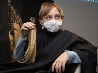 Ten-year-old Jackson Jost Noob holds some of his hair that was cut off in Sudbury, Ont. on Friday February 18, 2022.