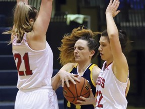 Helena Lamoureux, middle, of Laurentian Voyageurs, drives to the basket during OUA basketball action against the York Lions at Laurentian University in Sudbury, Ont. on Thursday February 24, 2022. York defeated Laurentian 70-52. John Lappa/Sudbury Star/Postmedia Network