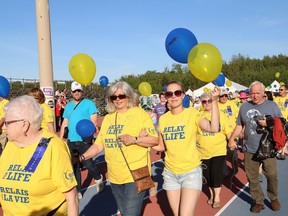People take part in the survivors' lap at the Canadian Cancer Society's Relay for Life at the track at Laurentian University in 2018. A Hope Ceremony for families affected by cancer will be held online on March 6.