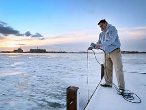 Mike McKay, executive director of the Great Lakes Institute for Environmental Research, is shown with a water quality monitor along the Detroit River banks in Windsor on Feb. 4. Dan Janisse /The Windsor Star