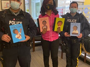 Fort Saskatchewan City Councillor and member of the Fort Black Society, Jibs Abitoye, posed with local police as they read books to local students in honour of Black History Month. Photo Supplied.