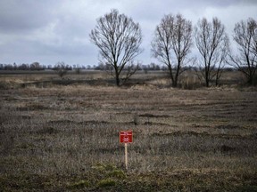 A sign reading 'Danger mines' on a wheat field northeast of Kyiv, Ukraine on March 3, 2022. PHOTO BY (PHOTO BY ARIS MESSINIS/AFP VIA GETTY IMAGES)