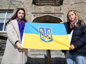 Queen’s University students and members of the Queen’s University Ukrainian Students' Association Emmy Lebed, left, and Katrina Korotky with the Ukrainian trident flag on the Queen’s University campus on Sunday.