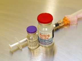 Vials of the Pfizer-BioNTech (left) and Moderna vaccines stand next to a syringe at Hastings Prince Edward Public Health in Belleville. A mass-vaccination clinic in Picton will be providing shots on Thursdays through March.