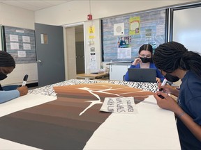 Cutline – Chippewa Secondary School students work on a mural that commemorates Black history and the power of education to eradicate racism. The mural is an International Baccalaureate (IB) project undertaken by Grade 11 students Rainat Salako and Omobola Agboola.