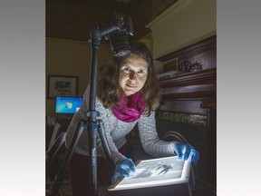 Brantford photographer Anca Gaston prepares to photograph a 8x10-inch glass plate negative at the Brant Museum and Archives on Monday.